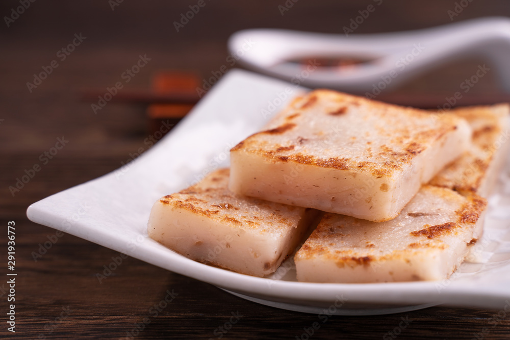 Delicious turnip cake, Chinese traditional local dish radish cake in restaurant with soy sauce and c