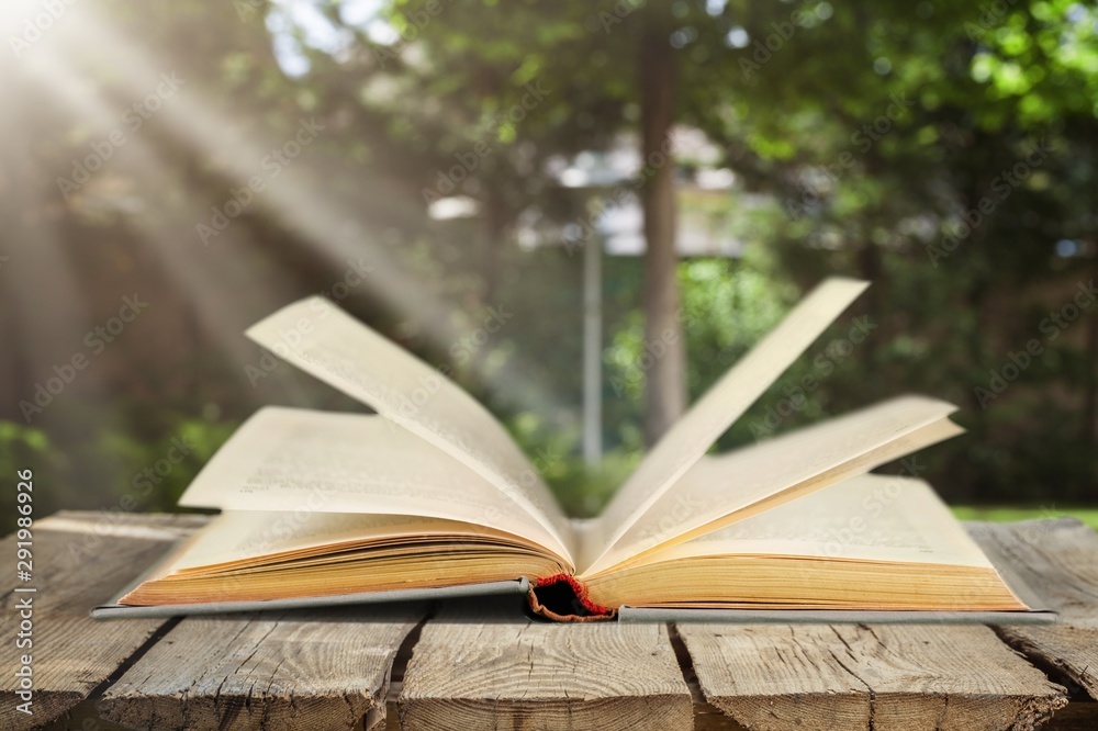 Open book on old wooden table.