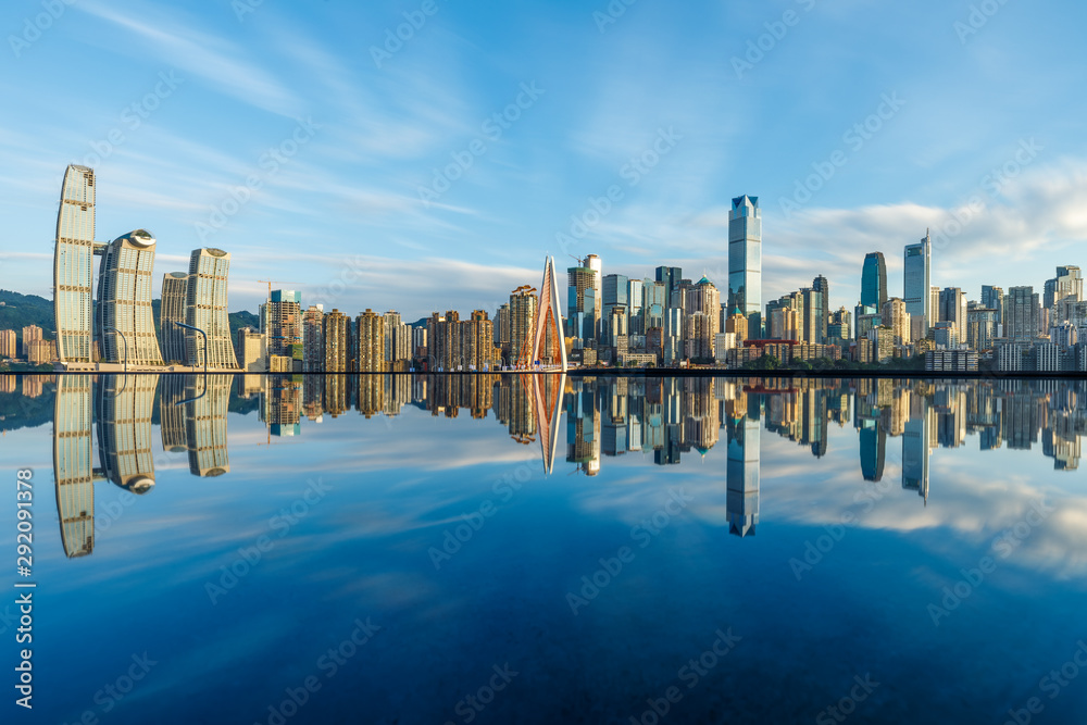 重庆天际线和现代城市摩天大楼，日落时水的倒影，中国。