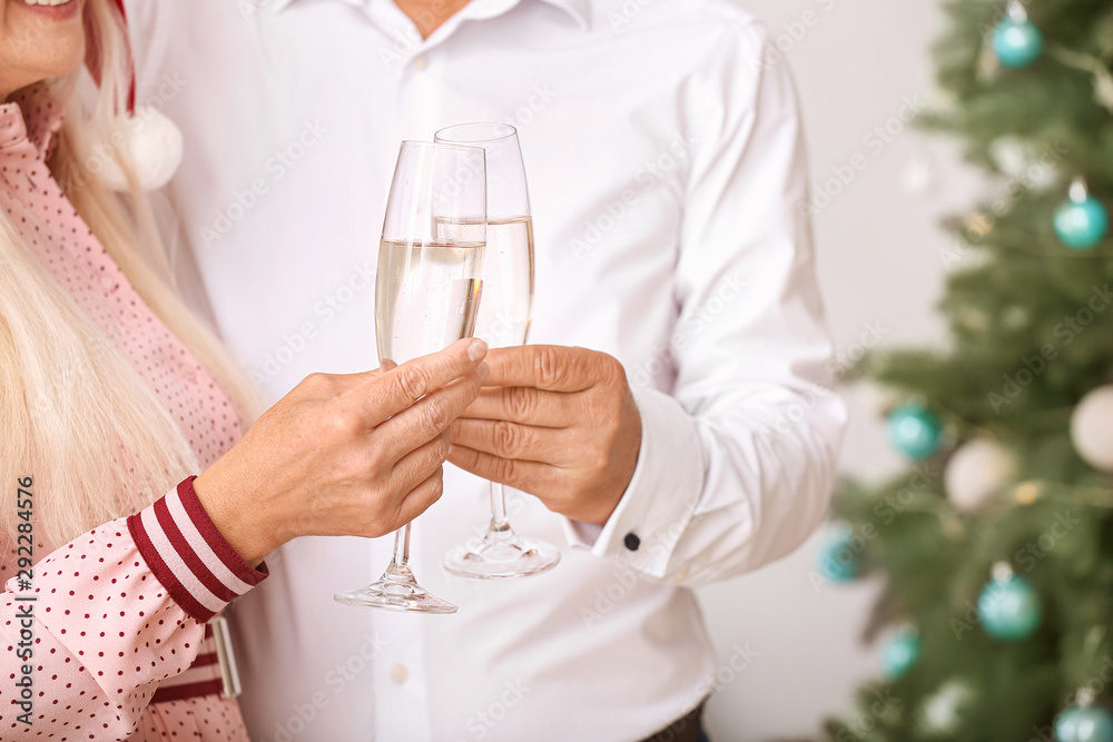 Mature couple with glasses of champagne celebrating Christmas at home