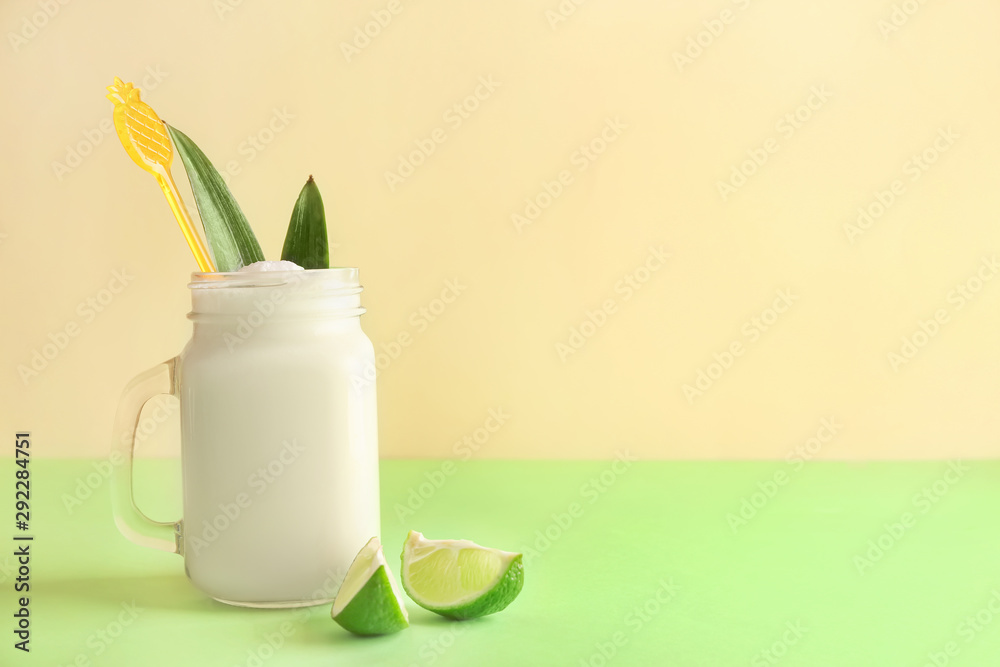 Mason jar of tasty Pina Colada cocktail on table