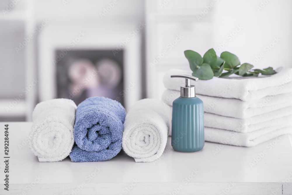 Soft clean towels with soap on table in bathroom