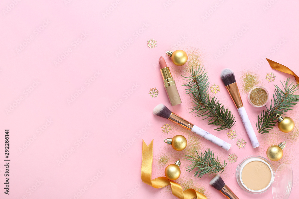 Set of cosmetics with makeup brushes and Christmas decor on color background