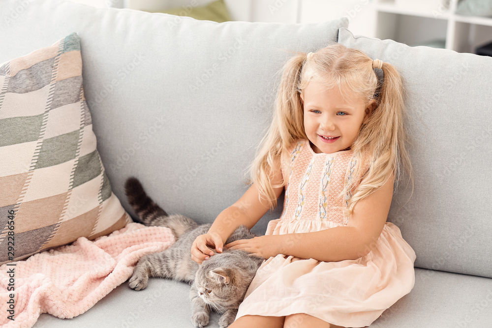 Little girl with cute cat at home