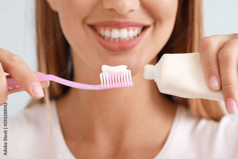 Woman with toothbrush and paste, closeup