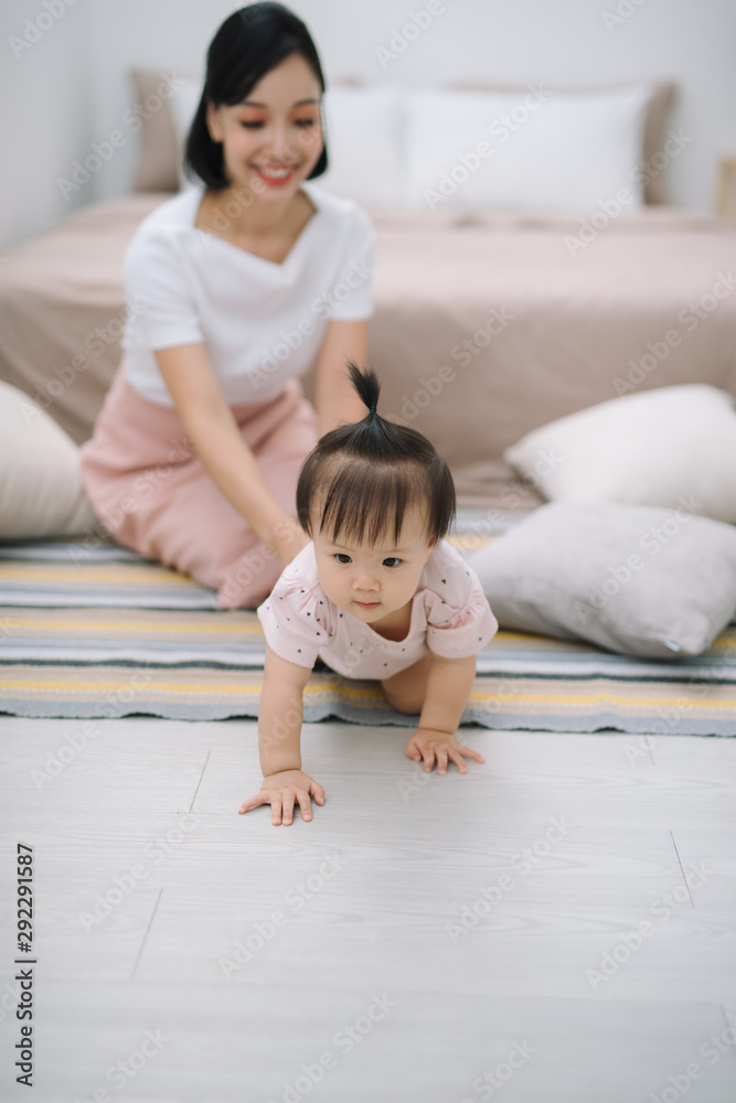 年轻的妈妈带着她可爱的小宝宝在家