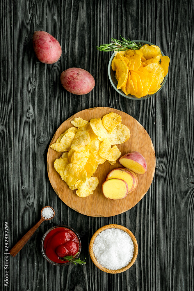 Cooking homemade potato chips with ketchup on wooden background top view