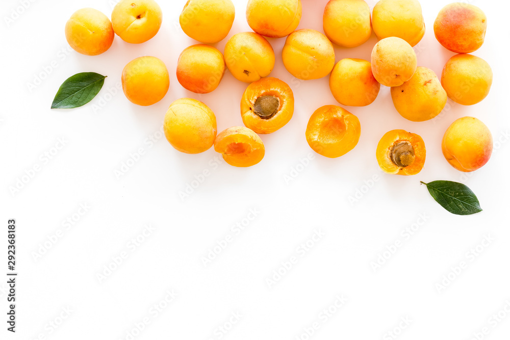 Fruit frame. Apricots and leaves on white background top view copy space