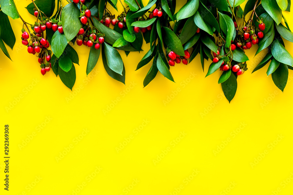 green herbs and red berries for summer design on yellow background top view mock up