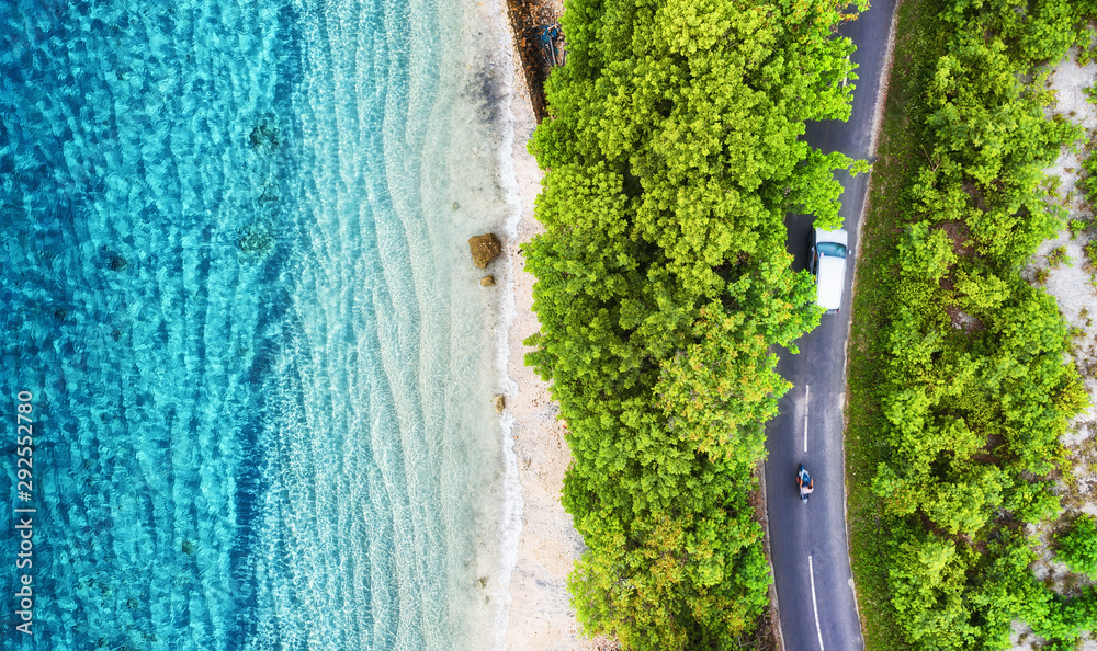 Aerial view on road in the forest. Highway throu the forest and sea coast. View from a drone. Natura