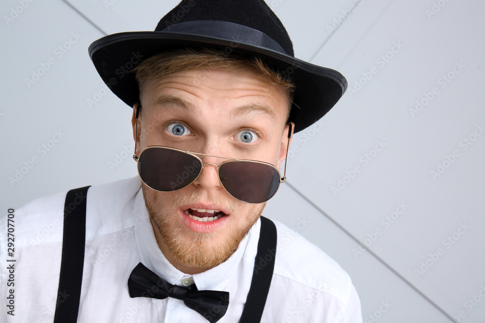 Surprised young man on light background