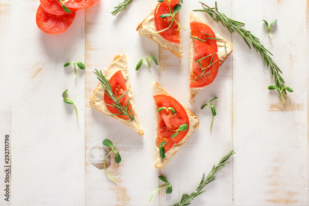 Tasty sandwiches on white wooden background