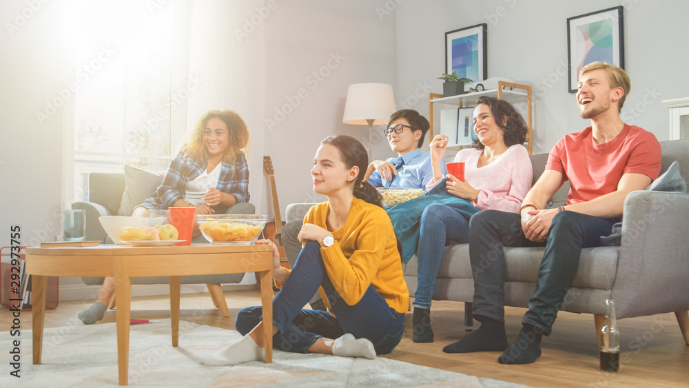 At Home Diverse Group Friends Watching TV Together, Eating Snacks and Drinking Beverage. They Probab