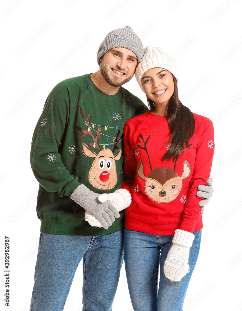 Young couple in Christmas sweaters on white background