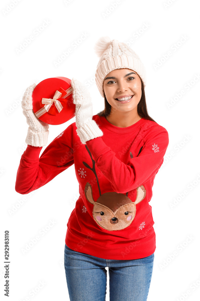 Young woman in Christmas sweater and with gift on white background