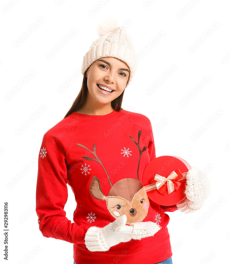 Young woman in Christmas sweater and with gift on white background