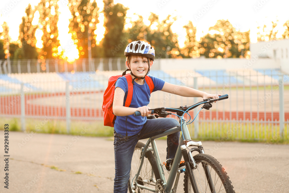 Cute boy riding bicycle outdoors