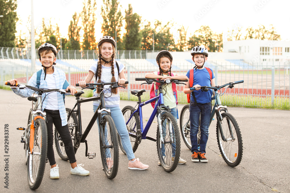 Cute children riding bicycles outdoors