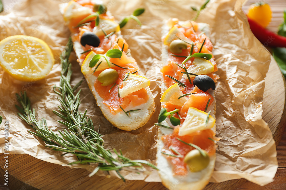 Tasty sandwiches with salmon on parchment