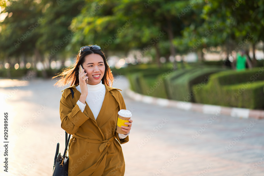 女人在户外喝咖啡打电话