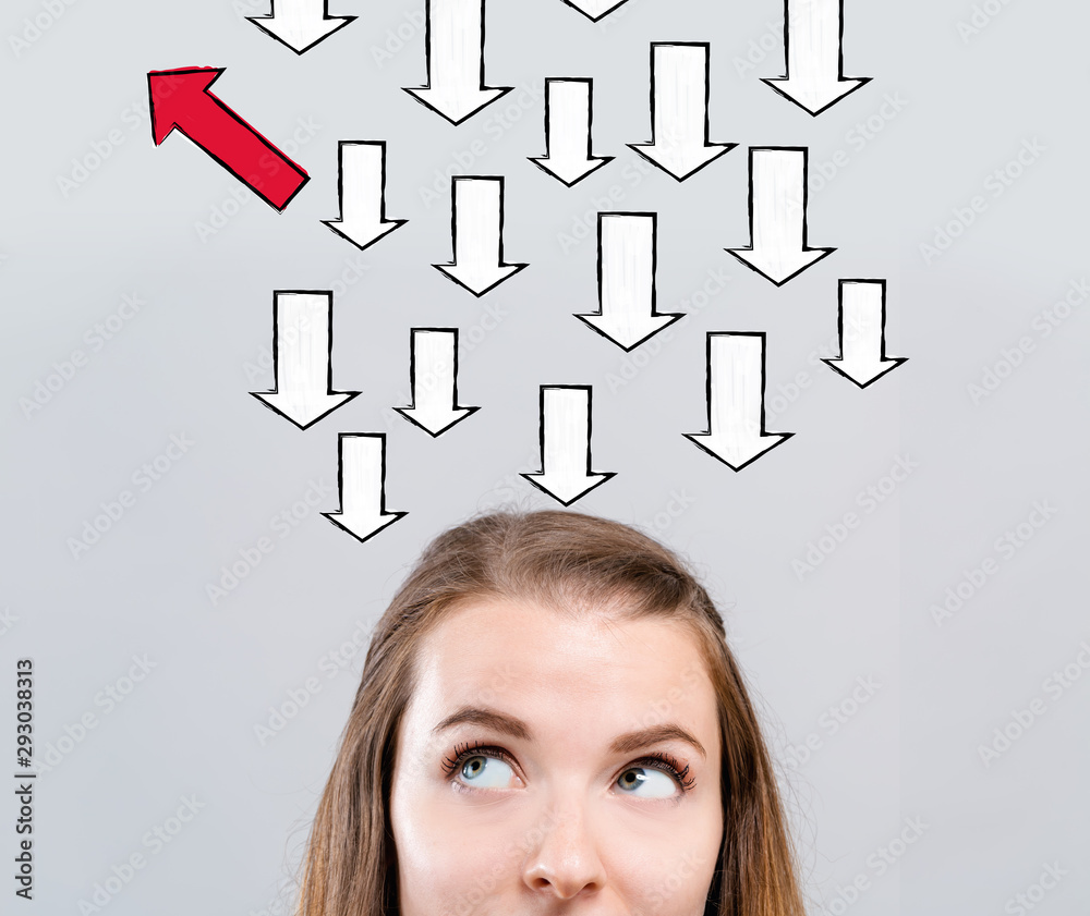 Arrow going in a different direction with young woman looking upwards