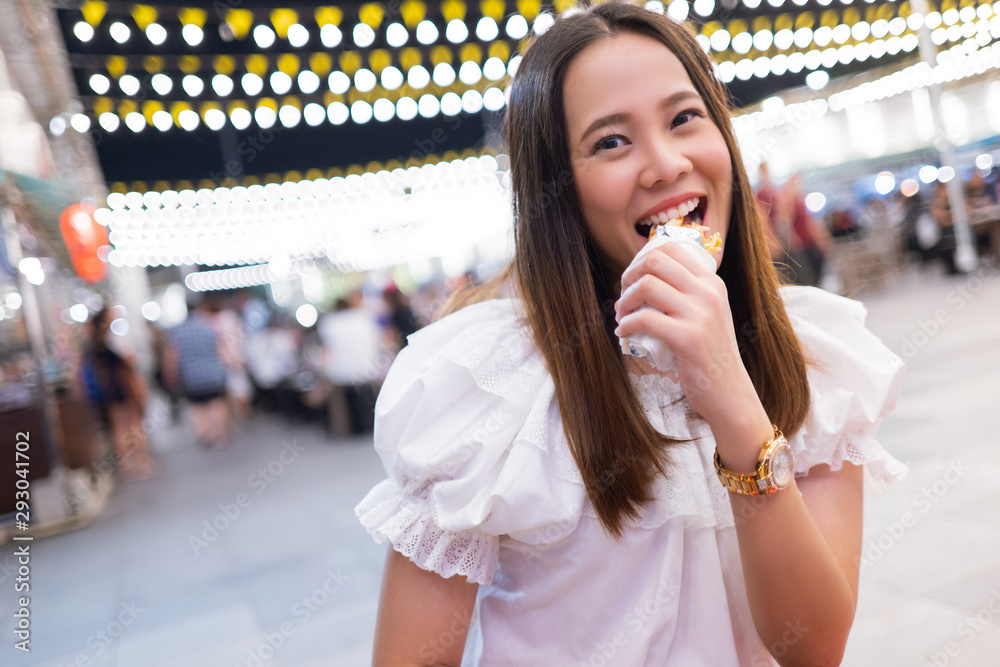 亚洲女游客晚上在泰国吃街头美食