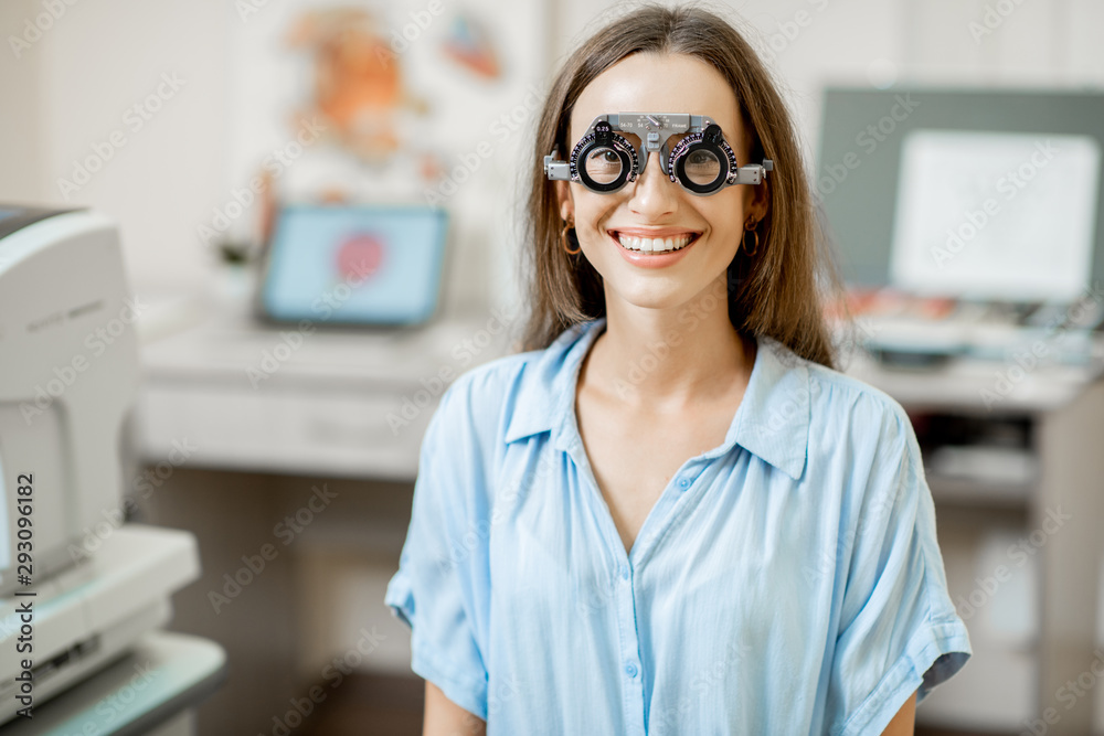 Young woman checking vision with eye test glasses during a medical examination at the ophthalmologic