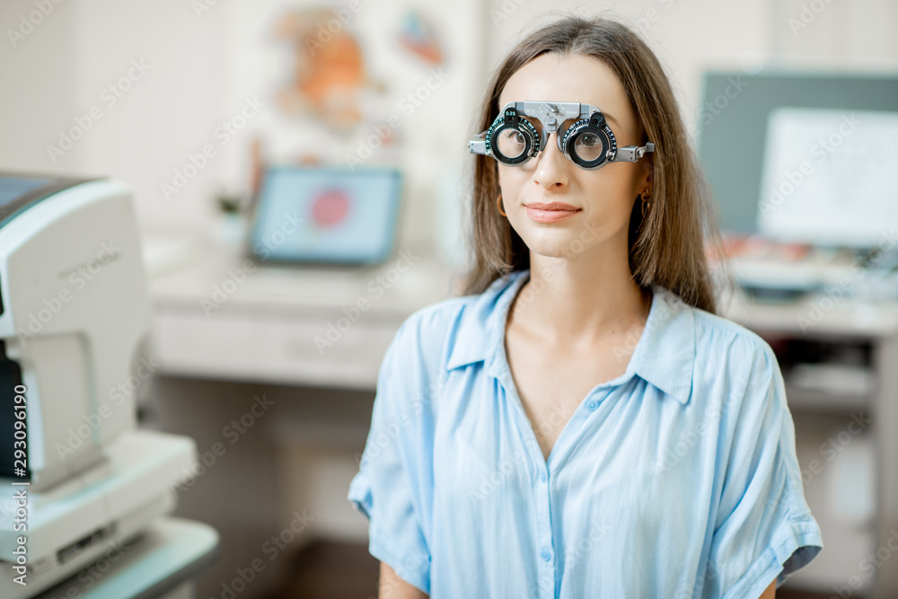 Young woman checking vision with eye test glasses during a medical examination at the ophthalmologic