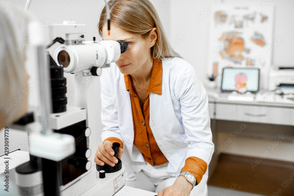 Ophthalmologist examining eyes of a senior patient using microscope during a medical examination in 