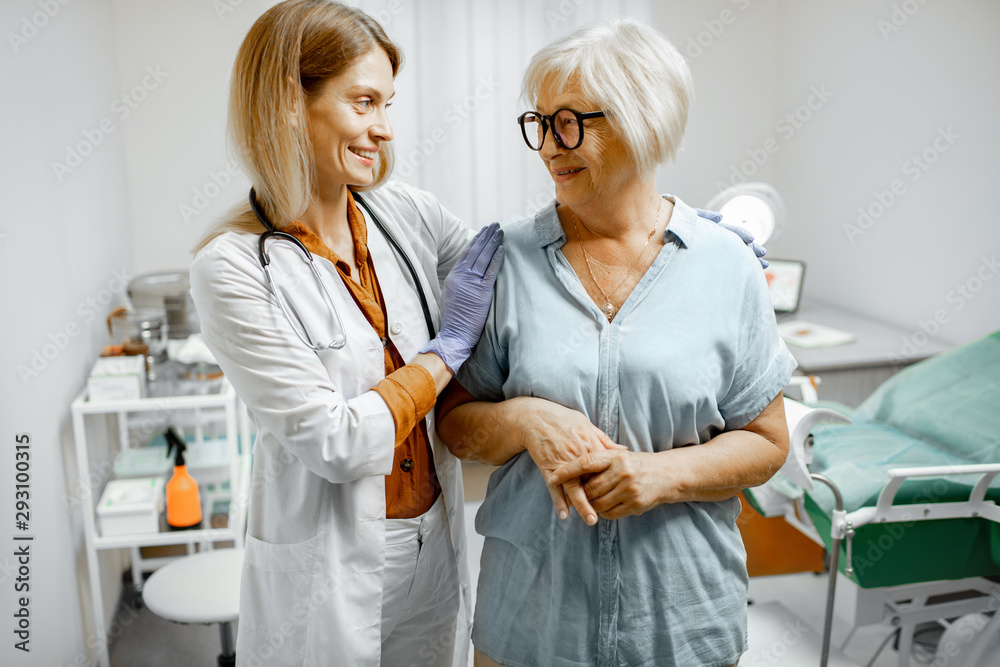 Gynecologist taking care of a senior woman patient, supporting and cheering her after the examinatio