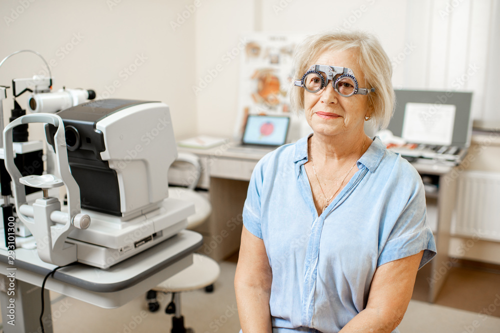 Senior woman checking vision with eye test glasses during a medical examination at the ophthalmologi