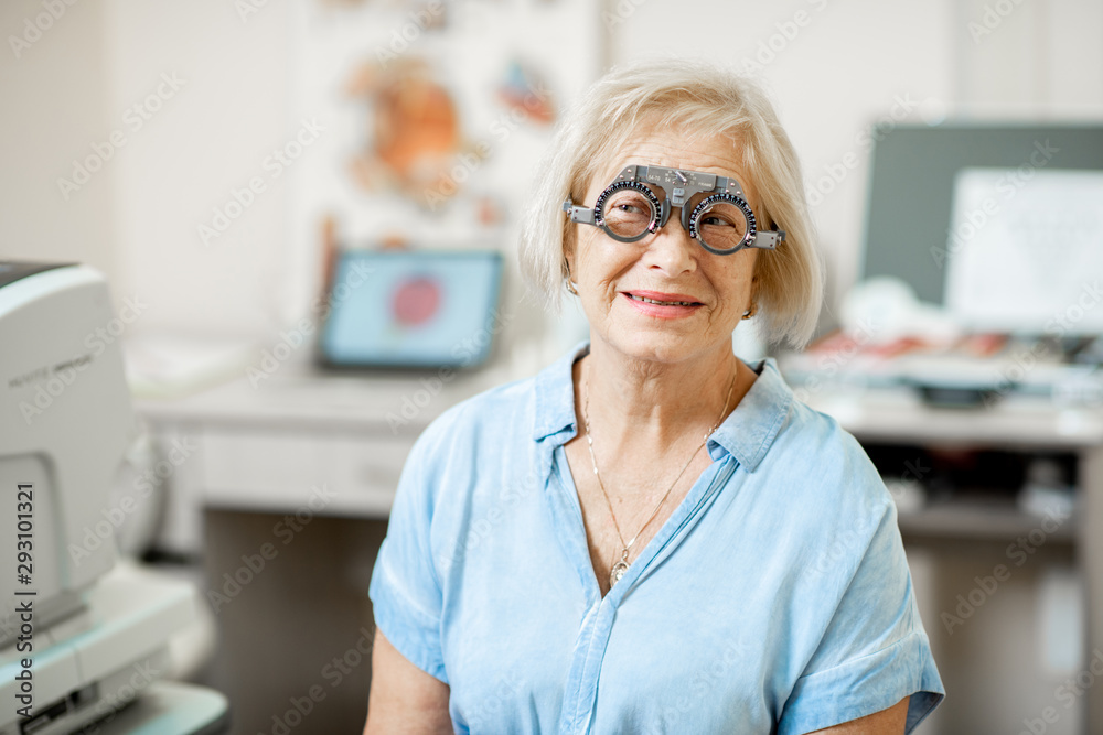 Senior woman checking vision with eye test glasses during a medical examination at the ophthalmologi