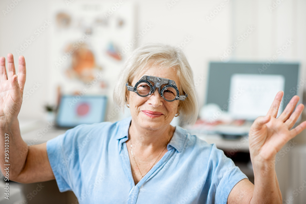 Senior woman checking vision with eye test glasses during a medical examination at the ophthalmologi