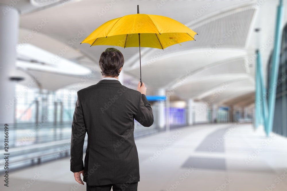 Portrait of  businessman with umbrella on background