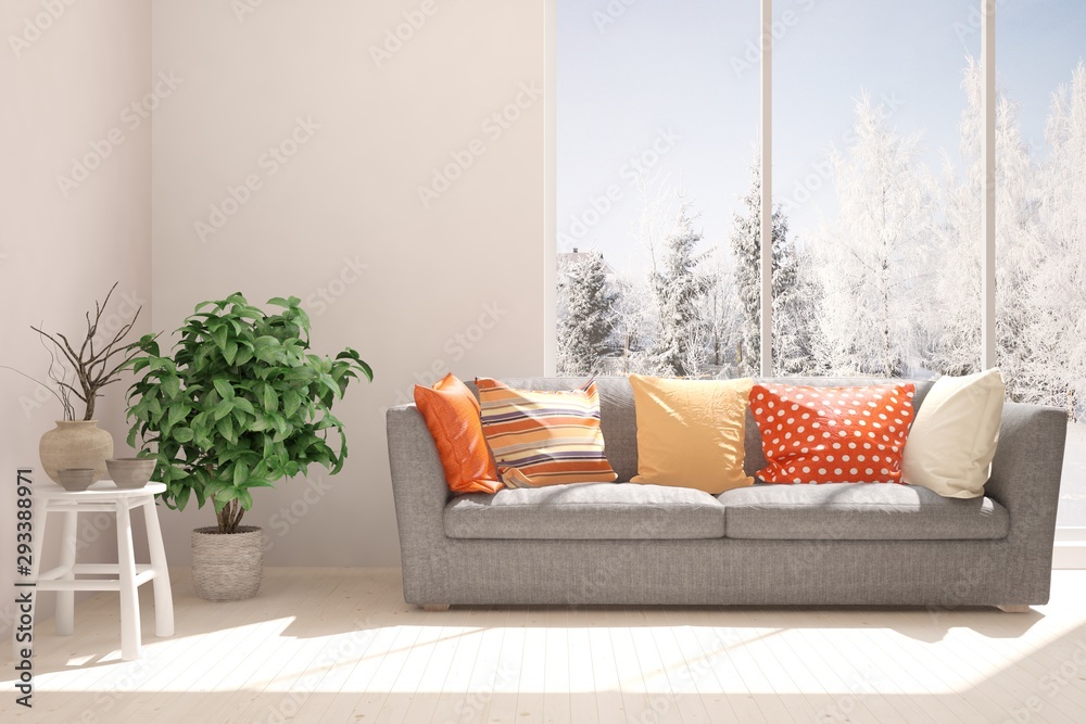 Stylish room in white color with sofa and winter landscape in window. Scandinavian interior design. 