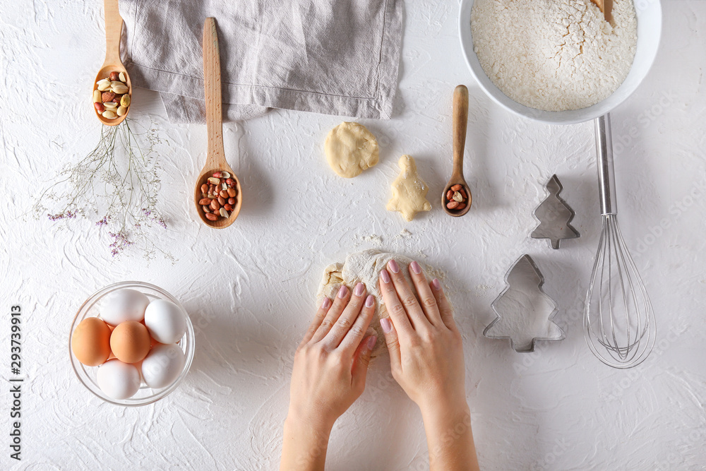 Woman kneading flour on white background