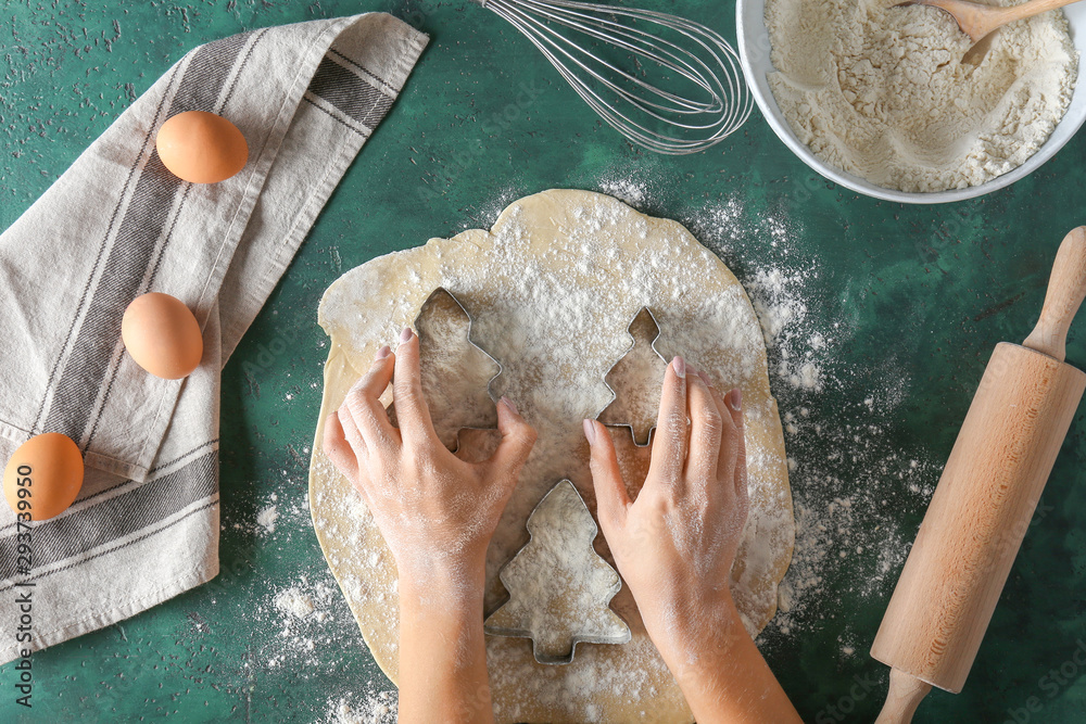 Woman preparing cookies on color background, top view