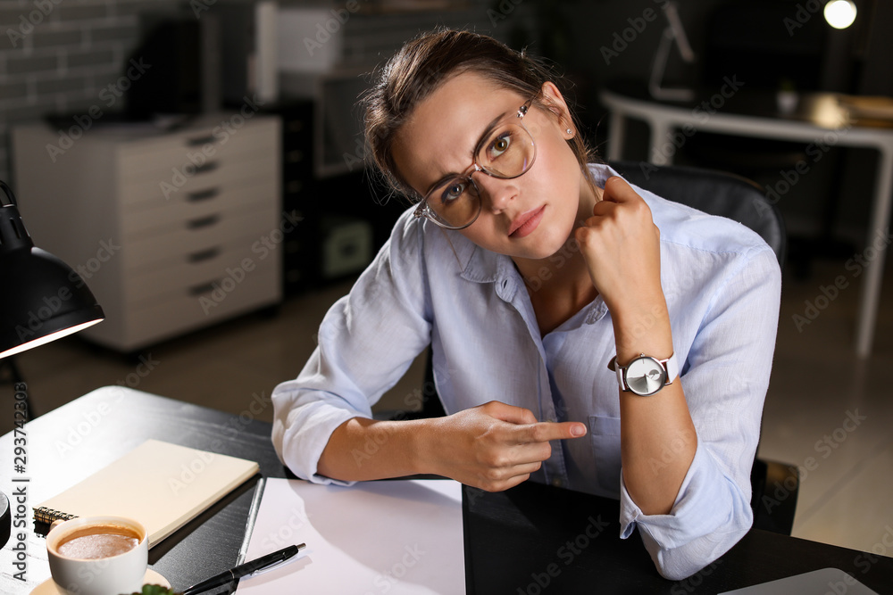 Tired businesswoman trying to meet deadline in office