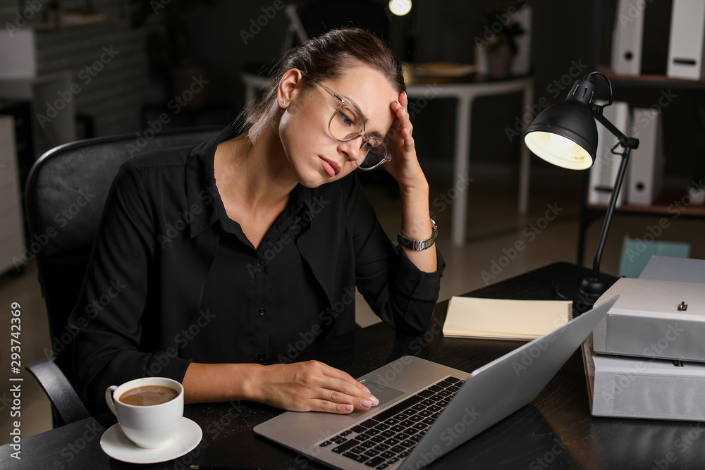 Tired businesswoman trying to meet deadline in office