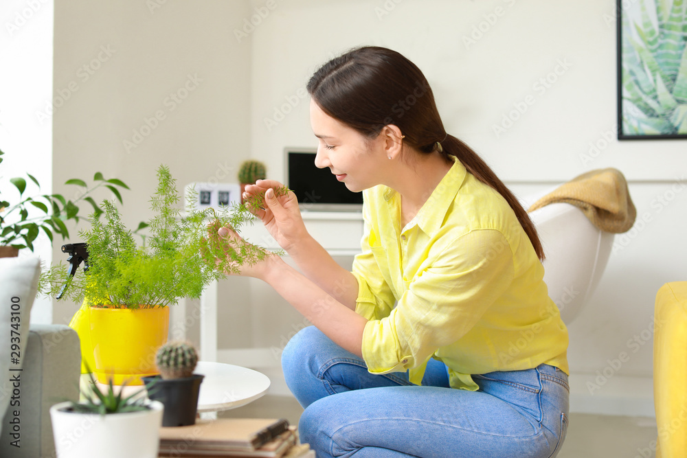 年轻女性在家照料室内植物