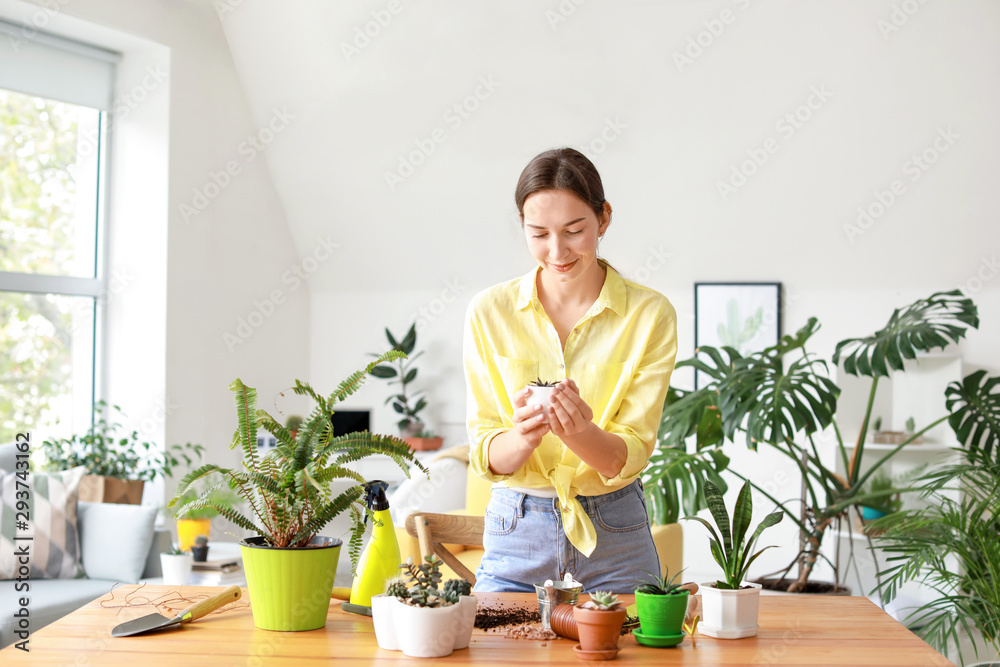 Young woman taking care for houseplants at home