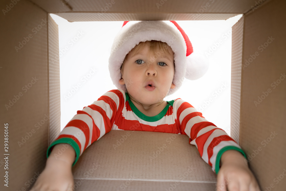 Surprised child unpack Christmas gift box