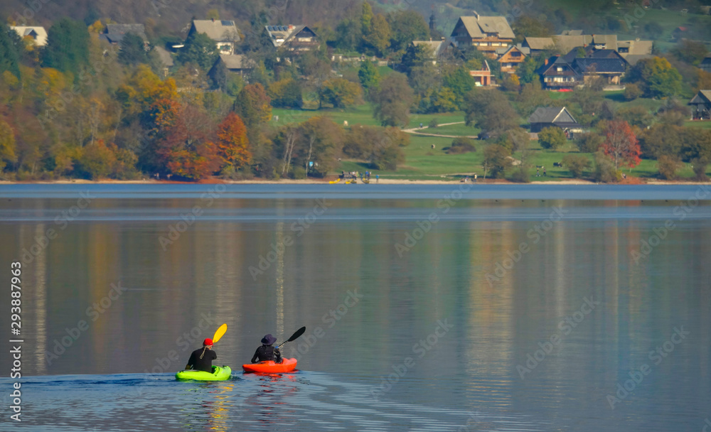 Two unrecognizable tourists go for a canoe trip around the scenic lake Bohinj.