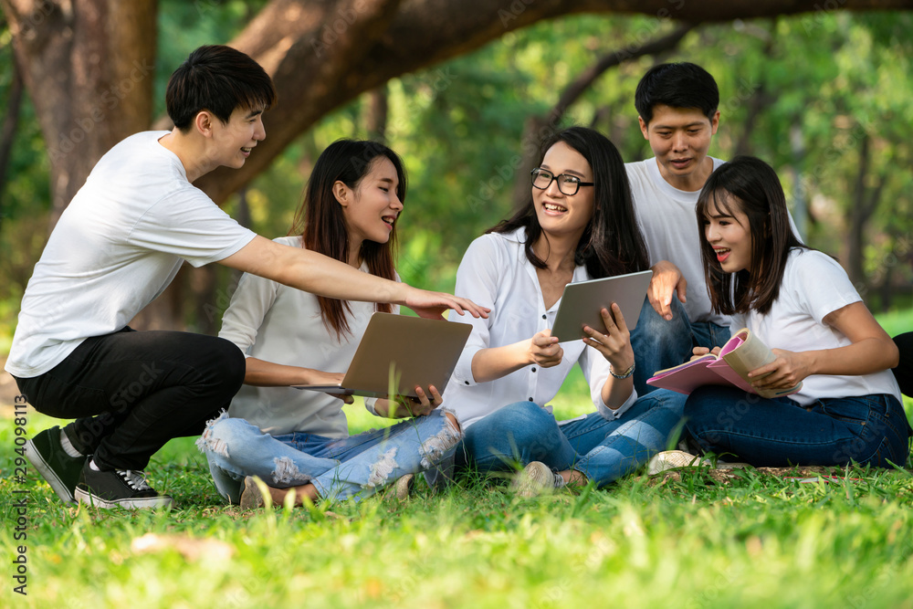 在大学或学校公园的小组项目中学习的年轻学生团队。学习快乐