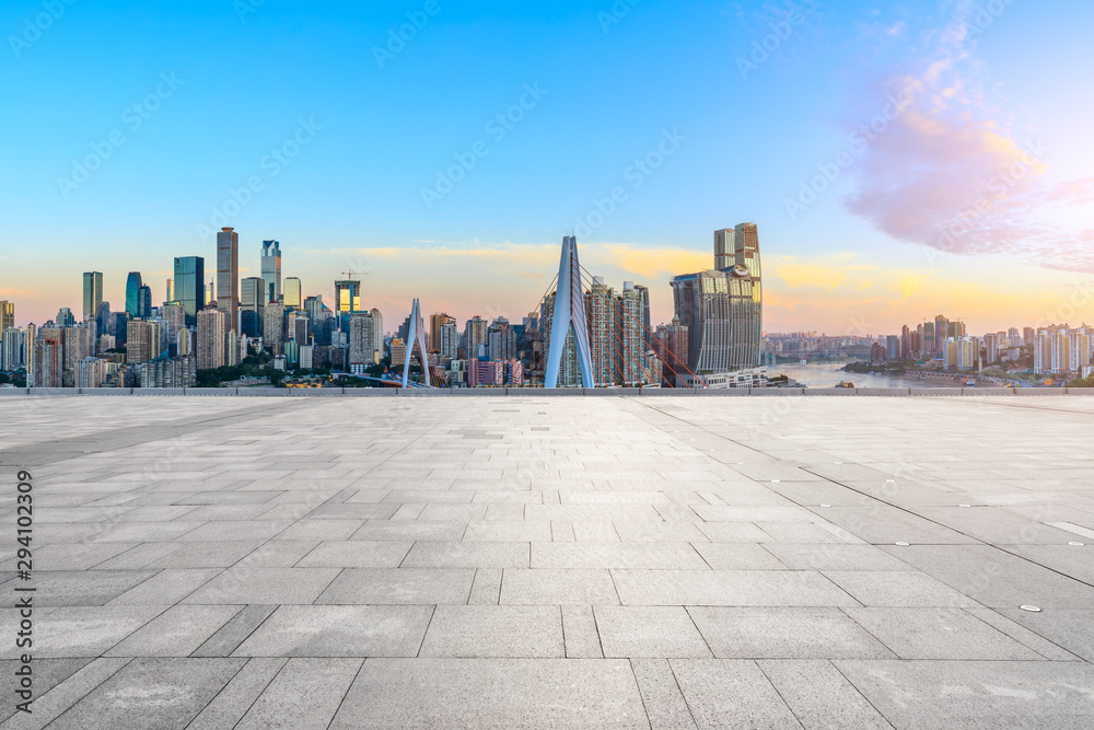 日出时，中国重庆的空旷广场和现代城市天际线。