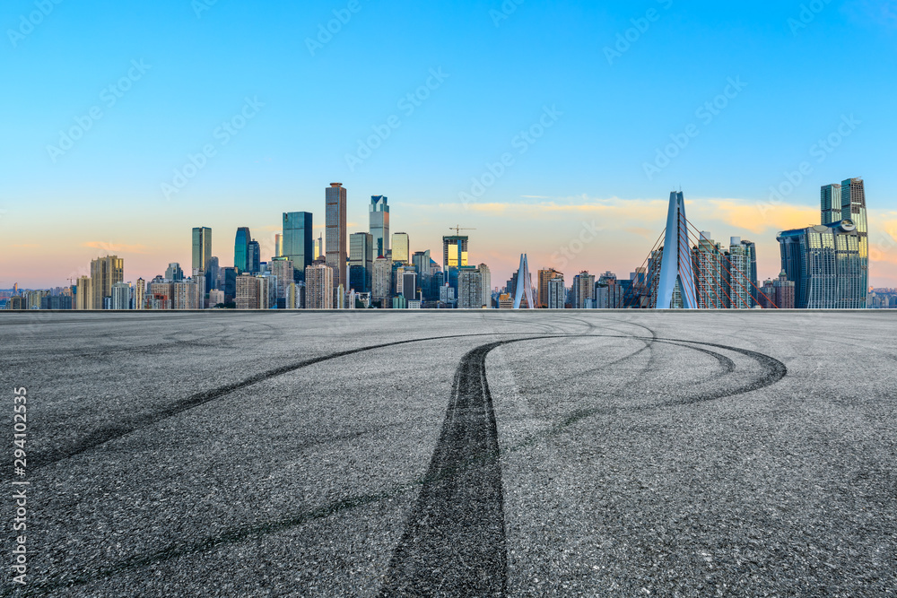 Empty race track ground and city financial district with buildings in Chongqing at sunrise,China.