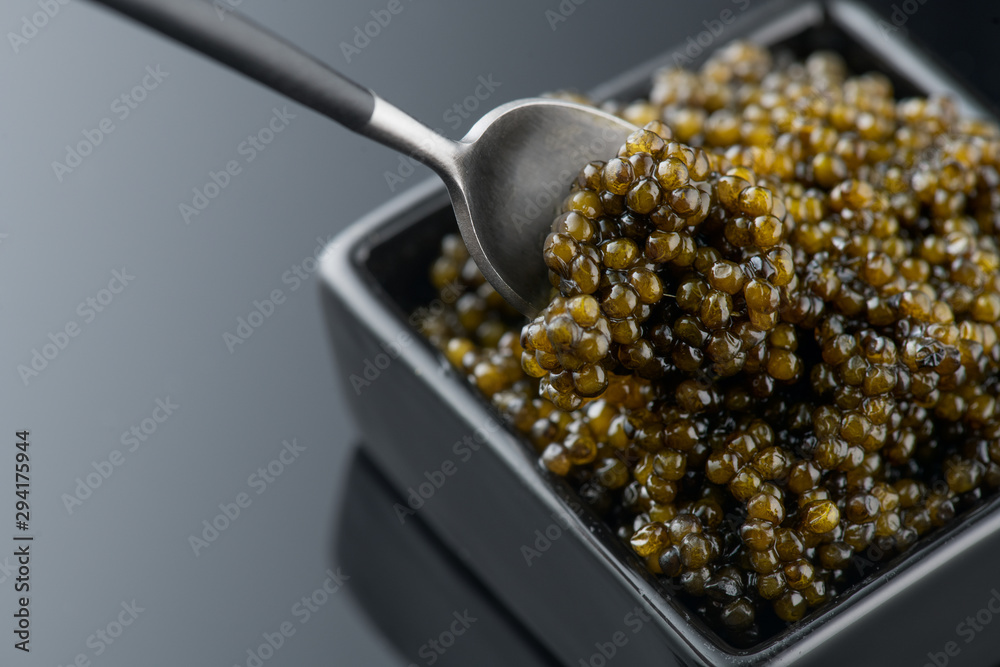 Black Caviar in spoon. High quality real natural sturgeon black caviar close-up. Delicatessen. Textu