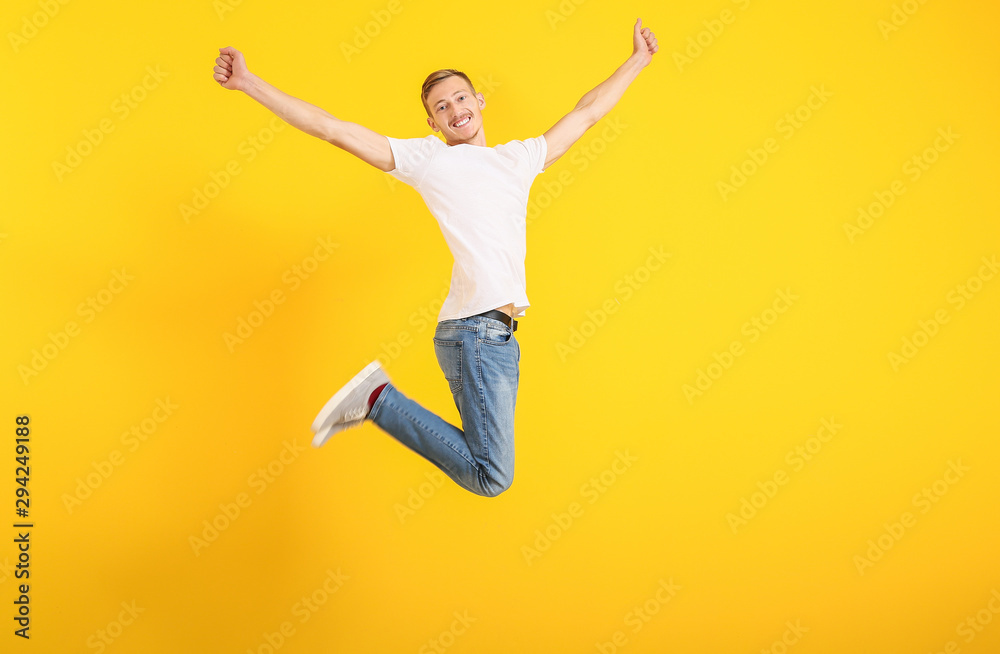 Jumping man in stylish t-shirt on color background