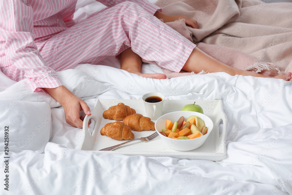 Young woman having breakfast in bed