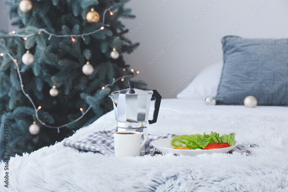 Tray with tasty breakfast in bedroom on Christmas eve